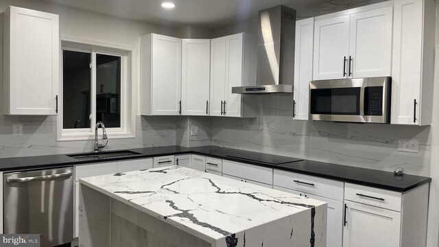123 Cumberland St, Cumberland, MD 21502 - kitchen with wall chimney range hood, backsplash, appliances with stainless steel finishes, a sink, and white cabinets