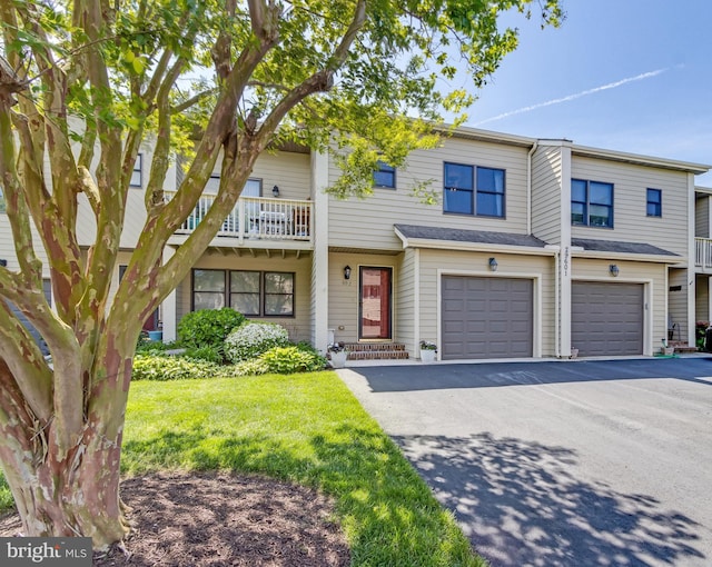 multi unit property with an attached garage, driveway, and a front yard