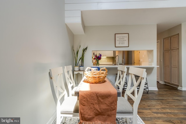 dining area featuring dark wood-type flooring and baseboards