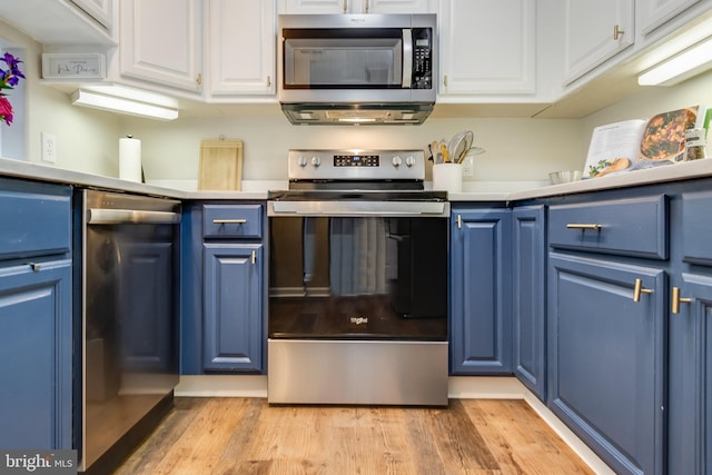 kitchen featuring white cabinets, stainless steel appliances, blue cabinetry, and light wood-style flooring