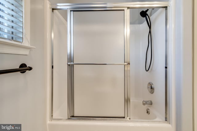 full bath featuring bath / shower combo with glass door
