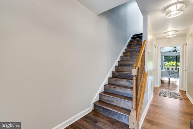 stairway with baseboards, ceiling fan, and wood finished floors