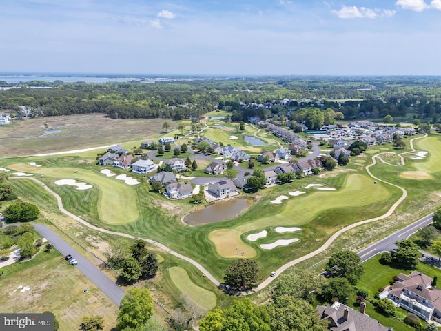 drone / aerial view featuring a water view, view of golf course, and a residential view