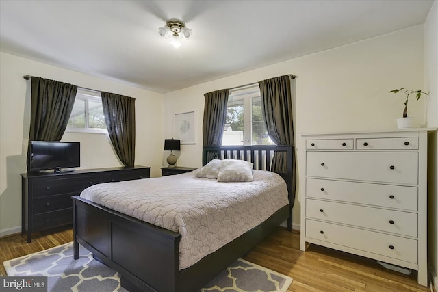bedroom featuring baseboards and wood finished floors