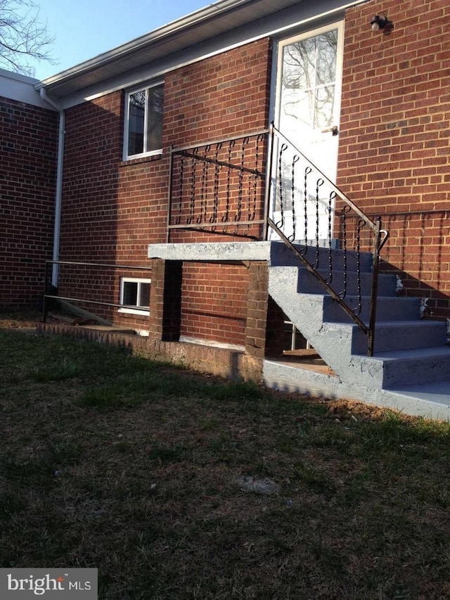 view of side of home with stairs and brick siding
