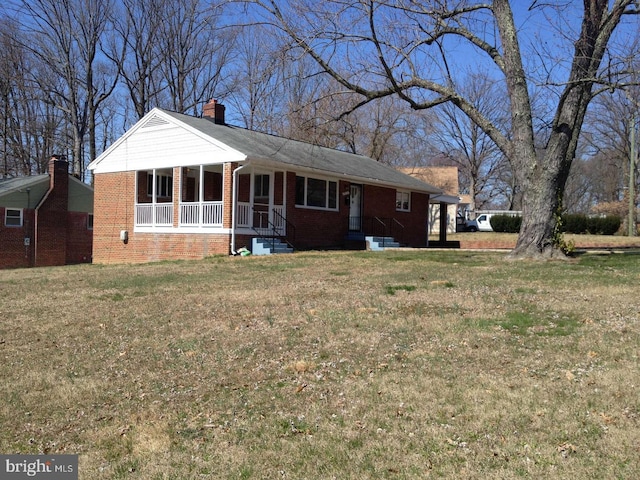 ranch-style house with brick siding, a chimney, and a front lawn