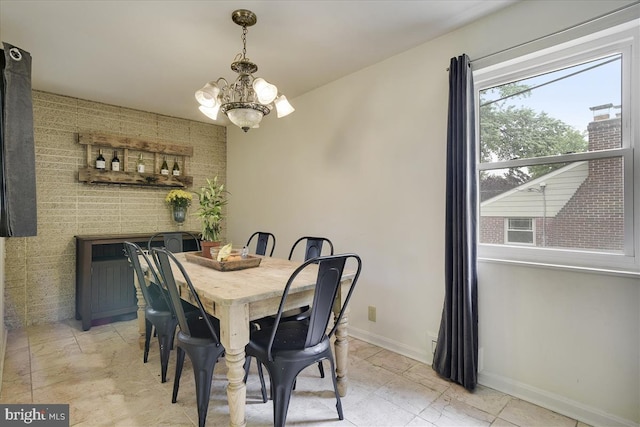 dining room with baseboards and a chandelier