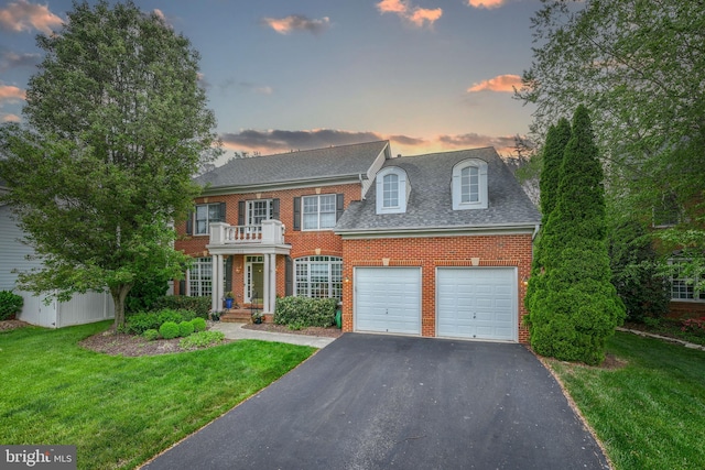 712 Pearson Point Pl, Annapolis, MD 21401 - colonial inspired home featuring brick siding, asphalt driveway, a front yard, a garage, and a shingled roof
