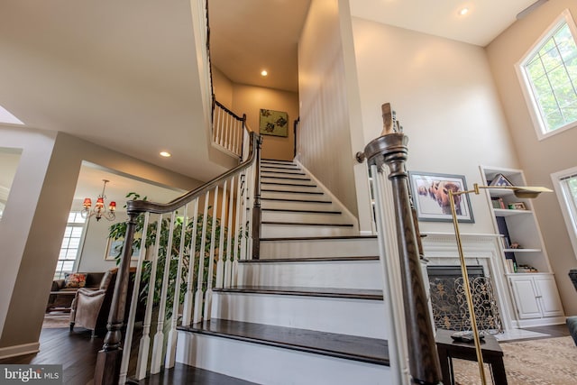 712 Pearson Point Pl, Annapolis, MD 21401 - stairway with wood finished floors, a chandelier, recessed lighting, a premium fireplace, and a towering ceiling