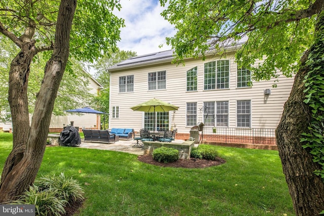 712 Pearson Point Pl, Annapolis, MD 21401 - rear view of house featuring an outdoor hangout area, a patio, roof mounted solar panels, and a lawn