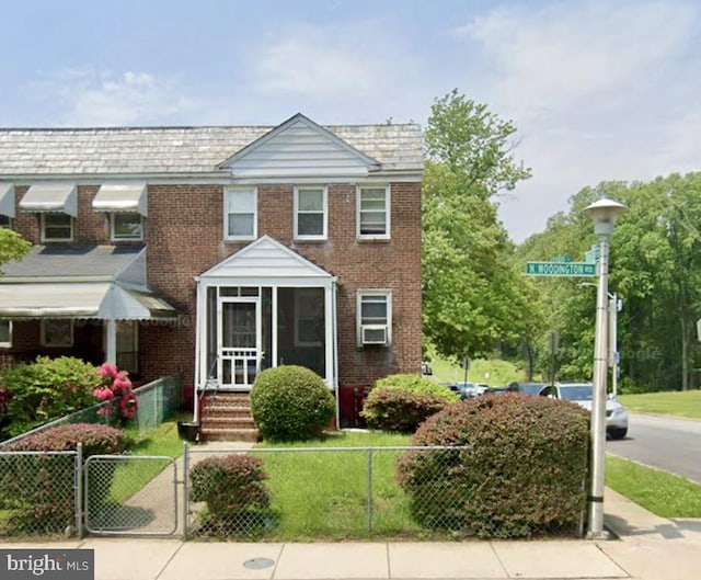 multi unit property with a fenced front yard, brick siding, and a gate