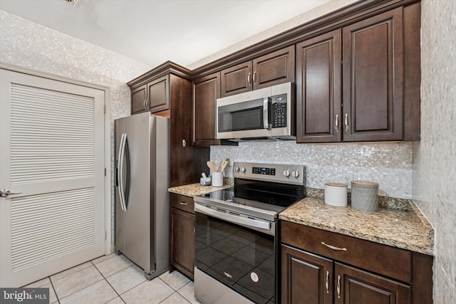 1600 Arch St Unit 1706, Philadelphia, PA 19103 - kitchen featuring light tile patterned floors, dark brown cabinets, stainless steel appliances, light stone countertops, and tasteful backsplash