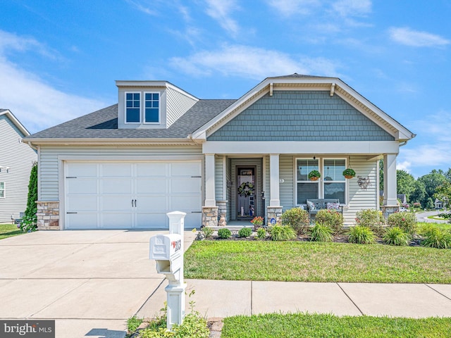 craftsman-style house featuring an attached garage, a porch, driveway, and stone siding