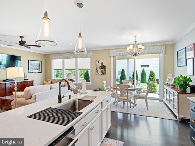 kitchen with crown molding, light stone countertops, a sink, white cabinetry, and dark wood-type flooring