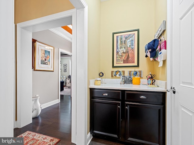 bar with crown molding, dark wood finished floors, and baseboards