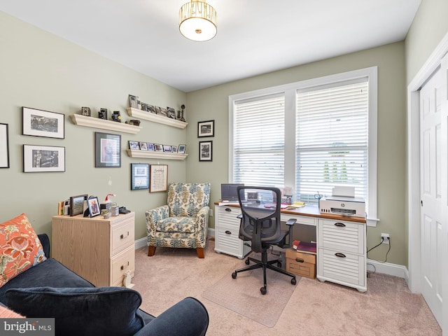 home office featuring baseboards and light carpet