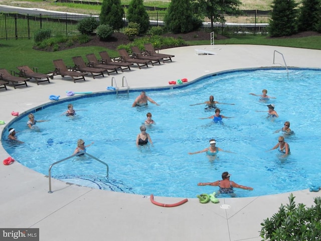 pool with a patio and fence