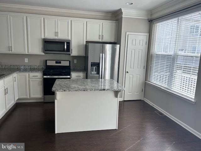 kitchen with baseboards, ornamental molding, stainless steel appliances, and light stone countertops