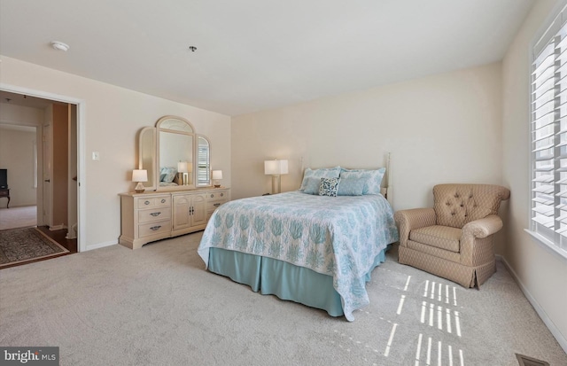 bedroom featuring carpet flooring, baseboards, visible vents, and multiple windows