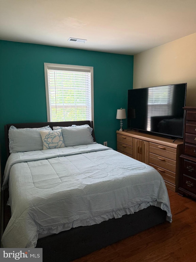 bedroom with visible vents and wood finished floors