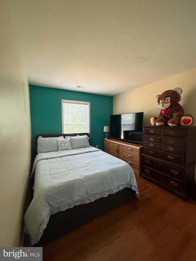 bedroom featuring visible vents and dark wood-type flooring