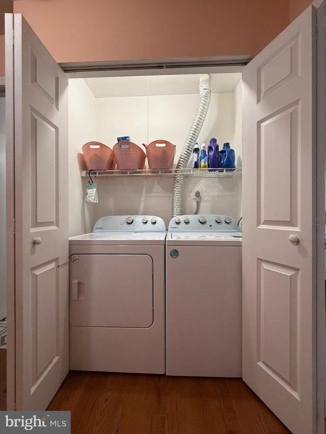 clothes washing area with laundry area, dark wood-style flooring, and washing machine and clothes dryer