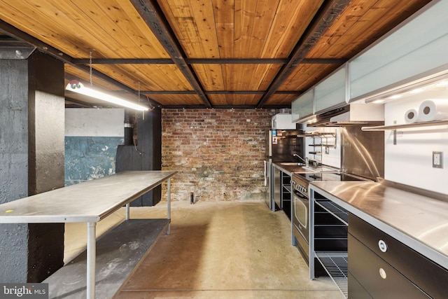 interior space featuring open shelves, stainless steel counters, stainless steel range with electric cooktop, concrete flooring, and under cabinet range hood