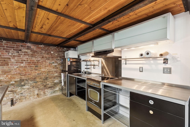kitchen featuring stainless steel appliances, stainless steel counters, concrete flooring, under cabinet range hood, and dark cabinetry