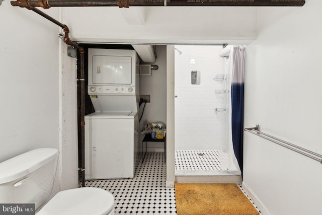 bathroom with toilet, a stall shower, and stacked washer and dryer