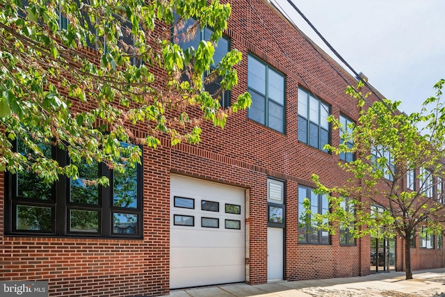 exterior space with an attached garage and brick siding