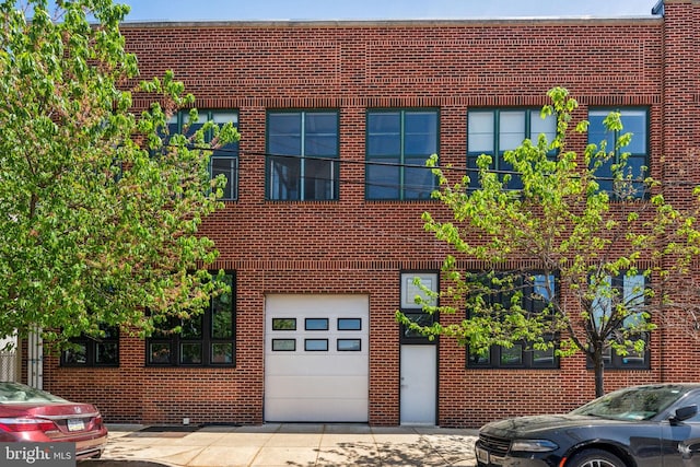 view of property with an attached garage and brick siding