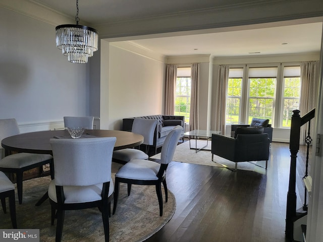dining space featuring crown molding, a chandelier, and wood finished floors