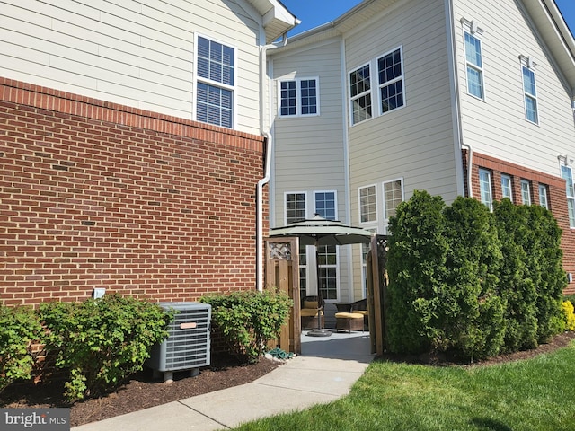 exterior space with central air condition unit and brick siding