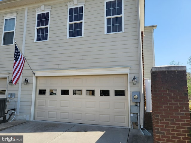 garage with central AC and concrete driveway