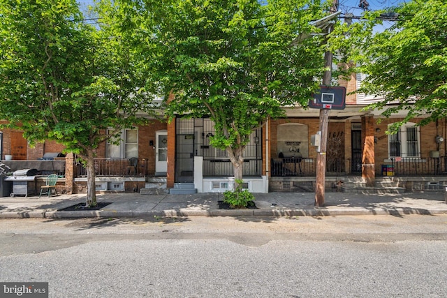 view of front of house with a porch and brick siding
