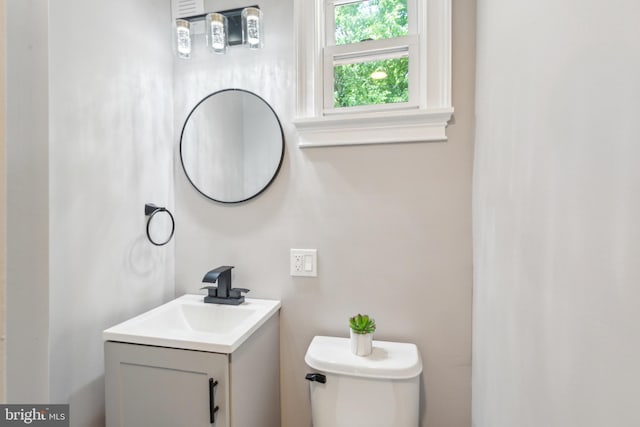 half bathroom with vanity and toilet