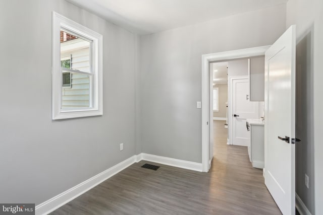 unfurnished bedroom featuring baseboards, visible vents, and dark wood finished floors