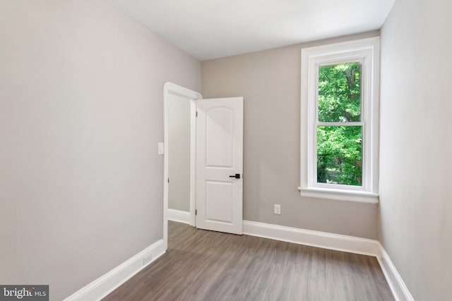 unfurnished room with wood finished floors and baseboards