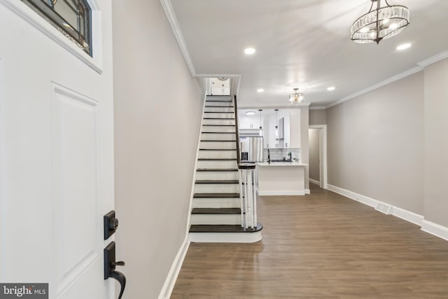 stairway with baseboards, ornamental molding, recessed lighting, and wood finished floors
