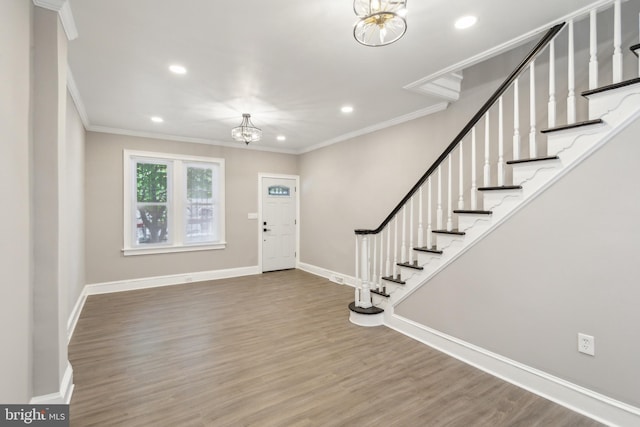 entryway featuring wood finished floors, crown molding, stairway, a chandelier, and recessed lighting