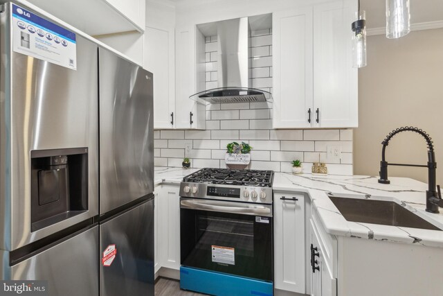 kitchen with a sink, white cabinetry, wall chimney exhaust hood, backsplash, and stainless steel appliances