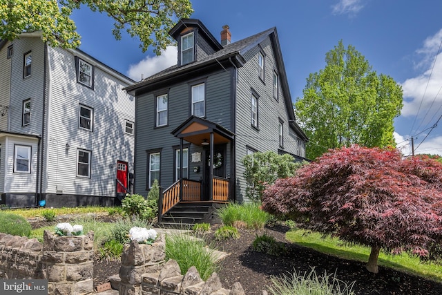 american foursquare style home with a chimney