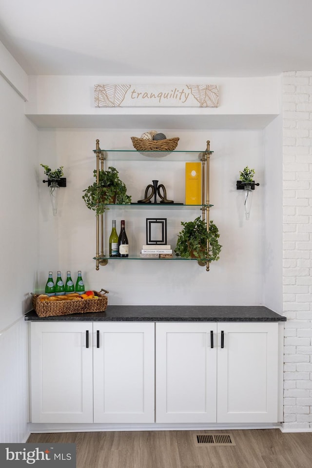 indoor dry bar with light wood-style flooring