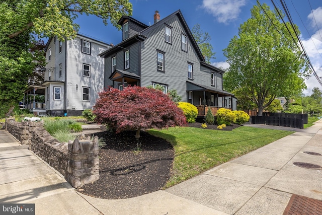 view of side of home featuring a porch and a chimney