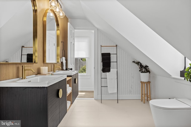 bathroom with vaulted ceiling, two vanities, and toilet