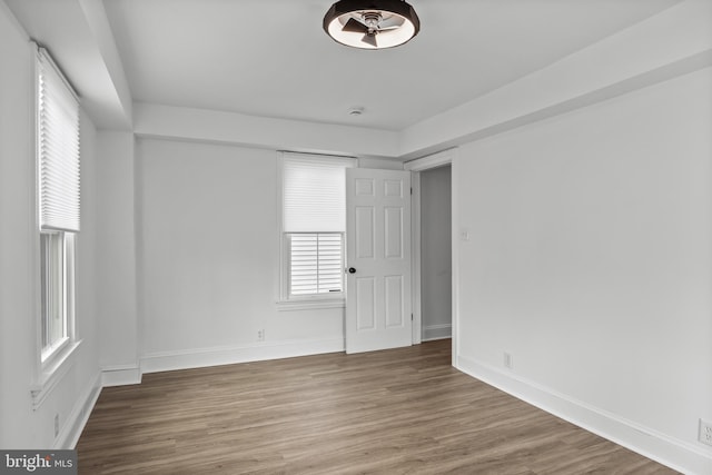 empty room featuring wood finished floors and baseboards