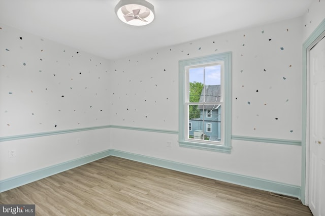 empty room featuring wood finished floors and baseboards