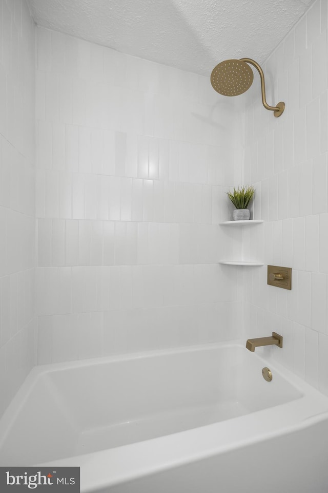 full bath featuring a shower, a textured ceiling, and a bath