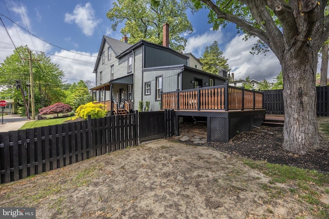 view of property exterior with a wooden deck and a chimney