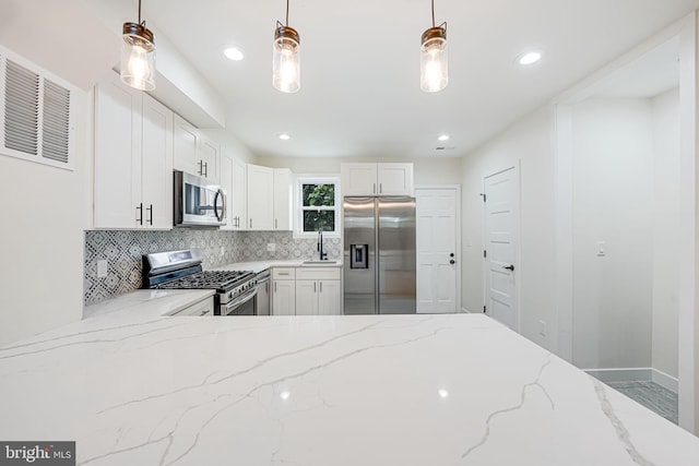 1621 Lyman Pl NE, Washington, DC 20002 - kitchen featuring appliances with stainless steel finishes, decorative backsplash, decorative light fixtures, white cabinetry, and recessed lighting